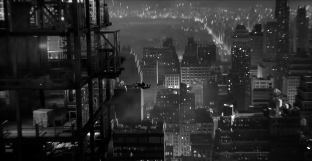 Spider Noir falls from skyscrapper featuring a black and white New York city in the background