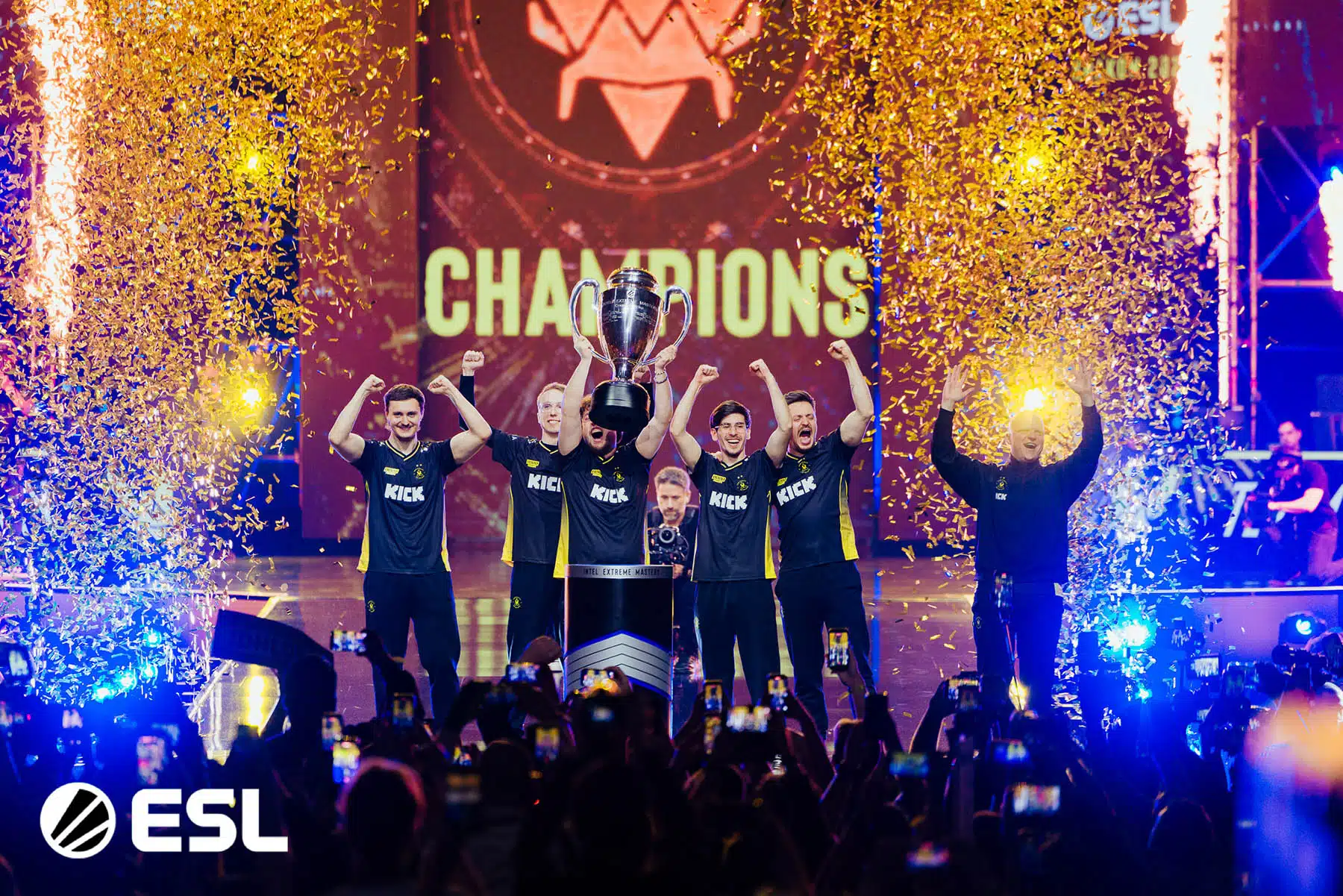 ZywOo and Team Vitality lifting the IEM Krakow 2026 trophy at TAURON Arena with confetti falling and crowd celebrating